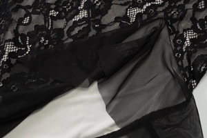 Detail of layered black floral lace over white lining and sheer mesh fabric textures