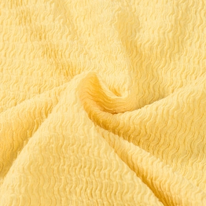 Gros plan sur la texture du tissu seersucker jaune avec des motifs froissés élastiques