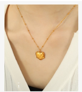 Detailed close-up of 18K gold-plated heart hug pendant necklace on a female model