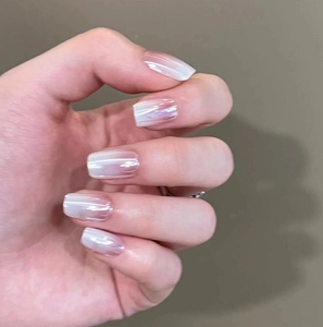 Macro detail of pearlescent pink and white ombre square-shaped press-on nails