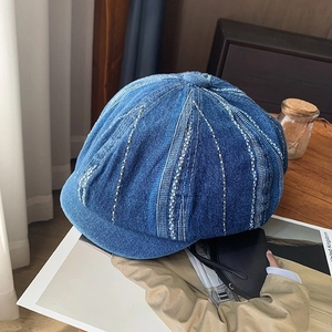Detail of washed blue denim beret with white stripe stitching and vintage worn finish