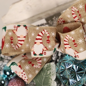 Detail of Christmas ribbon with gnome print on rustic faux burlap for festive tree decor