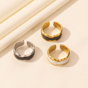 Three irregular wave rings in gold and silver with black and white enamel inlays