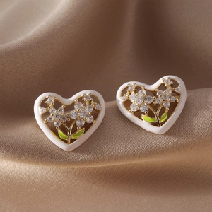 Hollow heart flower stud earrings with green enamel leaves and clear cubic zirconia