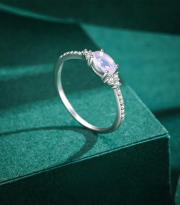 Macro shot of oval cut purple gemstone ring in 925 sterling silver on a green velvet box