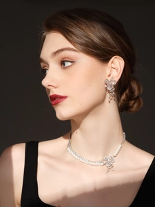 Elegant floral jewelry set with white pearls and sparkling zircons worn by a model