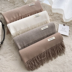 Solid color cashmere-feel scarves in beige, white, grey, and camel with tassels