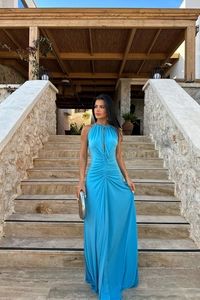 Detail of the elegant blue halter neck dress featuring slim-fit ruched waist and cut-out front