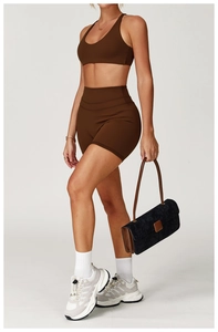 Vista di profilo del set sportivo marrone da donna con top racerback e pantaloncini a vita alta