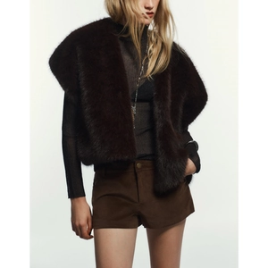 Detail of dark brown faux fur vest with metal buttons and soft plush texture