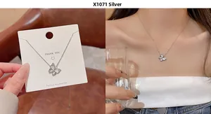 Detail of silver butterfly pendant necklace with zircon accents on a model and card