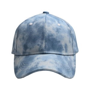 Detail of blue and white tie-dye cotton canvas baseball cap with embroidered daisy