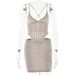 Détail d'un ensemble en tricot beige avec haut à découpes et mini-jupe assortie