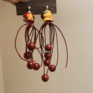 Detail von böhmischen roten Quastenohrringen mit Muschelperlen für den Sommerurlaub