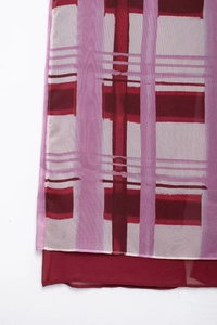 Detail of double-layered hemline featuring purple and burgundy plaid chiffon fabric