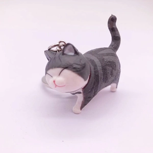 Detail view of a cute gray and white striped cat keychain with a smiling face and metal ring
