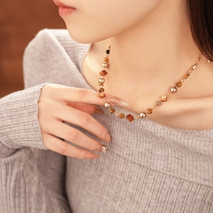 Detail view of geometric amber and gold beads on a retro style beaded necklace
