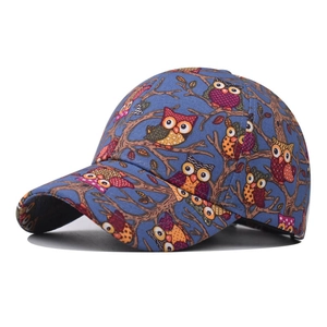 Blue cotton baseball cap with colorful owl print and curved brim in side front view