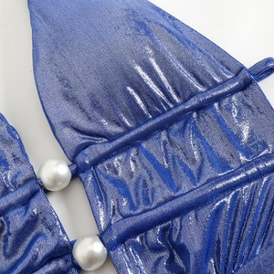 Macro detail of royal blue shiny fabric with pleats and elegant white pearl ornaments