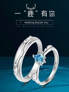 Detail of silver couple rings with antler motif and a sparkling blue round gemstone