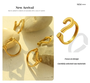 Macro detail of adjustable gold question mark ring on natural stone with soft shadows