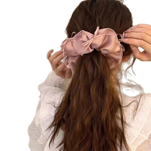 Pink satin oversized hair scrunchie with bow ribbon shown on model back view
