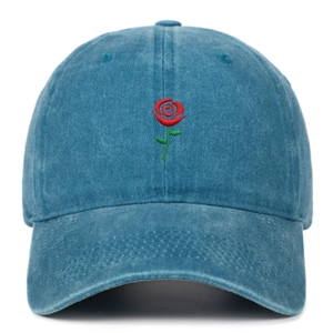 Close-up of red rose embroidery on a vintage washed blue cotton baseball cap