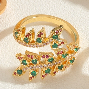Macro shot of gold leaf ring with micro-pave green and red zircons and fine details