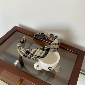 Detail of plaid fabric headband with hand-made label on a vintage jewelry box