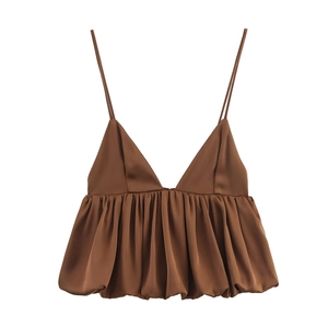 Détail d'un caraco en satin marron à fines bretelles avec une texture soyeuse luxueuse