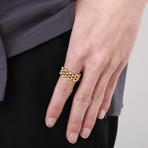 Close-up of golden stainless steel chain ring inspired by watch strap design on finger