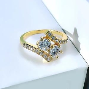 Anillo geométrico dorado de doble piedra con circonitas en un diseño cruzado