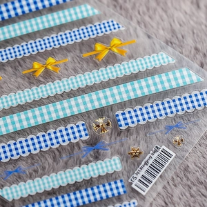 Detail of 5D embossed nail stickers featuring blue plaid and yellow bowknot designs