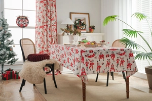 Detail of Santa Claus print on red cotton linen tablecloth with a festive Christmas scene