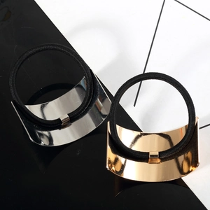 Golden and silver metal cuff hair ties with brushed finish on a modern geometric background