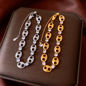 Detailed close-up of zircon link bracelet on a luxury brown jewelry display box