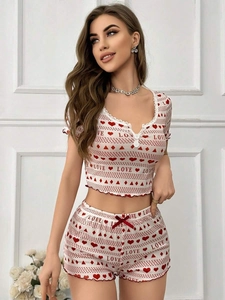 Detail of ribbed knit pajamas with love heart print and white lace neckline trim