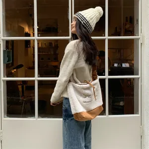 Détail du sac cabas en peau de mouton avec broderie CRÈME et empiècement en toile marron