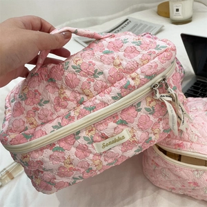Detail of pink floral quilted cosmetic bag with cute bunny patterns and sturdy zipper