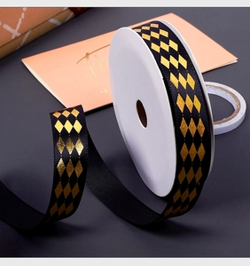 Detail of black grosgrain ribbon with gold rhombic patterns for luxury gift wrapping