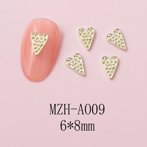 Detail of 6x8mm gold heart nail art charm with textured surface on pink background