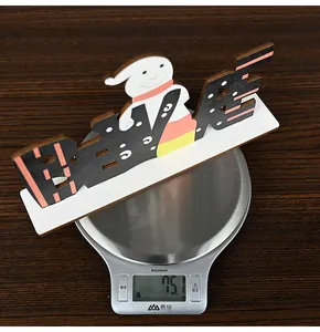 Detailed top view of Halloween BOO wood decor weighing 75.1g on a digital scale