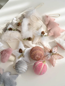 Close-up of plush Christmas tree ornaments in champagne and pink Morandi tones