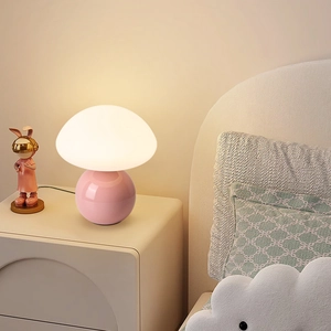 Pink mushroom ceramic table lamp with warm glow on bedside table for bedroom decor