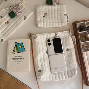 Detailed shot of cream quilted cotton bags with delicate floral embroidery and cute charms