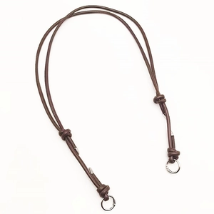 Close-up of adjustable brown leather bag strap with metal ring clasps and polished silver tips