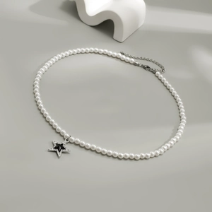 Collana di perle da uomo con pendente a stella con strass su sfondo minimalista
