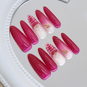 Deep rose red and white almond press-on nails with 3D texture and gold bead accents