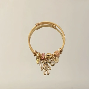 Gold stainless steel wrap bracelet with rhinestone bear and pink enamel charms