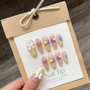 Faux ongles dégradé pastel avec nœuds 3D blancs et charms en forme de cœur colorés